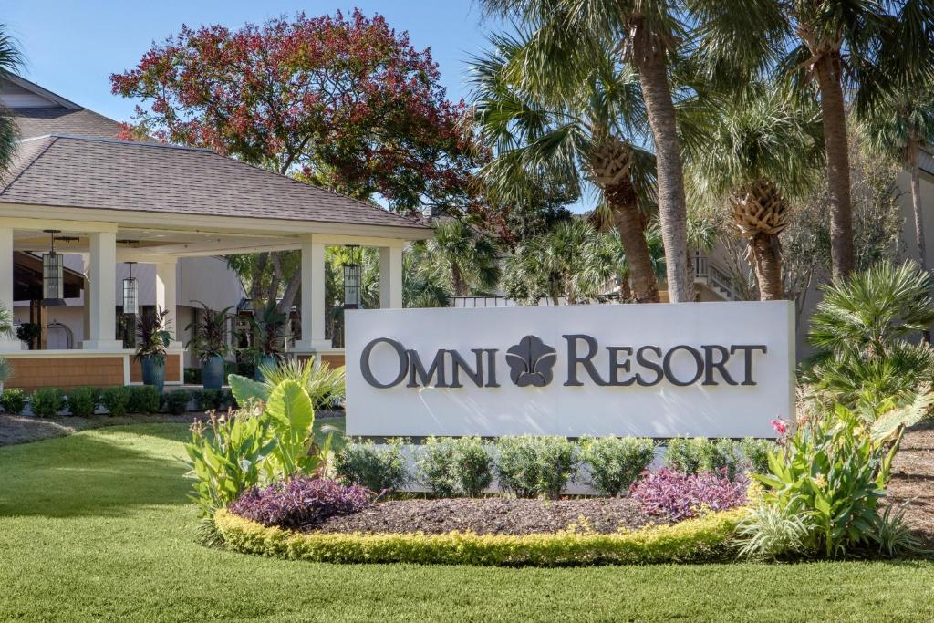 Entrance sign for Omni Resort surrounded by palm trees and landscaped gardens.