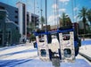 Close-up of empty swing seats at the Orlando Starflyer ride, with a building and palm trees in the background.