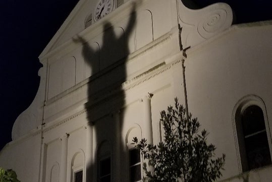 A large shadow appears on a building