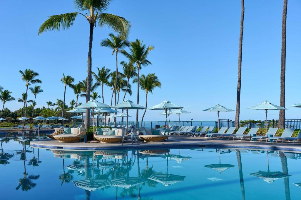 Refreshing outdoor pool with daybeds and sun loungers.