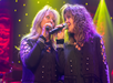 Two female singers, dressed in black,  performing on stage at the Ozarks Country show in Branson.