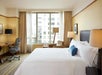One queen bed inside a guest room.