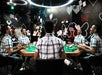 A man sits at a poker table surrounded by illusions of himself replicated multiple times with cards hover and whirl through the air at Paradox Museum Las Vegas, NV

