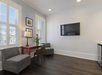 Seating area with two sofa and a flat-screen TV inside a guest room.