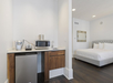 Single-cup coffee machine, microwave, sink and a mini-fridge inside a king room.
