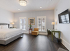 One king bed, work desk and a flat-screen TV inside a spacious and bright guest room.