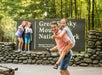 A family having fun at the Great Smokey Mountains National Park in front of the main enterance sign on the Gatlinburg Loop Smoky Mountains Tour in Gatlinburg, Tennessee.