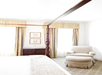 A king bed and a soft armchair and ottoman