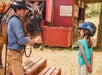 A man with a horse talking to a little girl with a helmet on at Gunstock Ranch in Oahu, Hawaii.