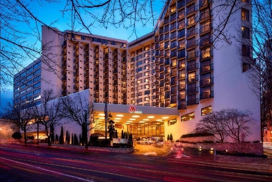 The front exterior and covered driveway and entrance to the Portland Marriott Downtown Waterfront  at dusk.