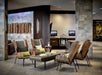 A modern style sitting area with four grey and wood chairs around a long coffee table in the lobby of the Portland Marriott Downtown Waterfront.