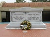 A marble tomb with inscriptions for Rev. Martin Luther King, Jr. and Coretta Scott King, adorned with a wreath of flowers at the base.