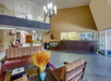 Hotel lobby with tiled floor, seating area with couches and chairs, front desk in the background, chandelier, decorative vases on tables, and a staircase leading to the upper level.