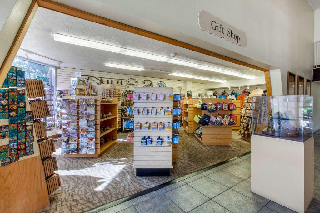 Interior of a gift shop with shelves displaying various items such as postcards, snacks, and souvenirs. A sign reading "Gift Shop" is above the entrance.