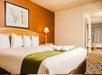 One king bed and bedside lamp inside a bedroom in a guest room.