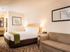 One king bed, bedside lamps, and seating area in a bedroom.
