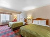 Two queen beds, bedside lamps, and air condition in a guest room.
