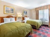 Two queen beds, bedside lamps, and air condition in a guest room.