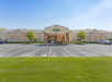 Front view of a two-story Quality Inn hotel with a large parking area and neatly trimmed grass.