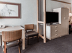 Work desk and a flat-screen TV inside a guest room.
