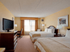 A non-smoking room with a flat-screen TV, two queen beds, and a laptop-friendly work desk.