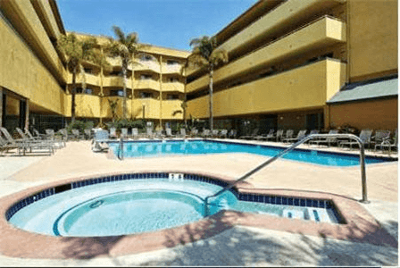 Hot tub and outdoor pool area with sun loungers.