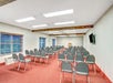 Meeting room with chairs, a podium and a flat-screen TV.