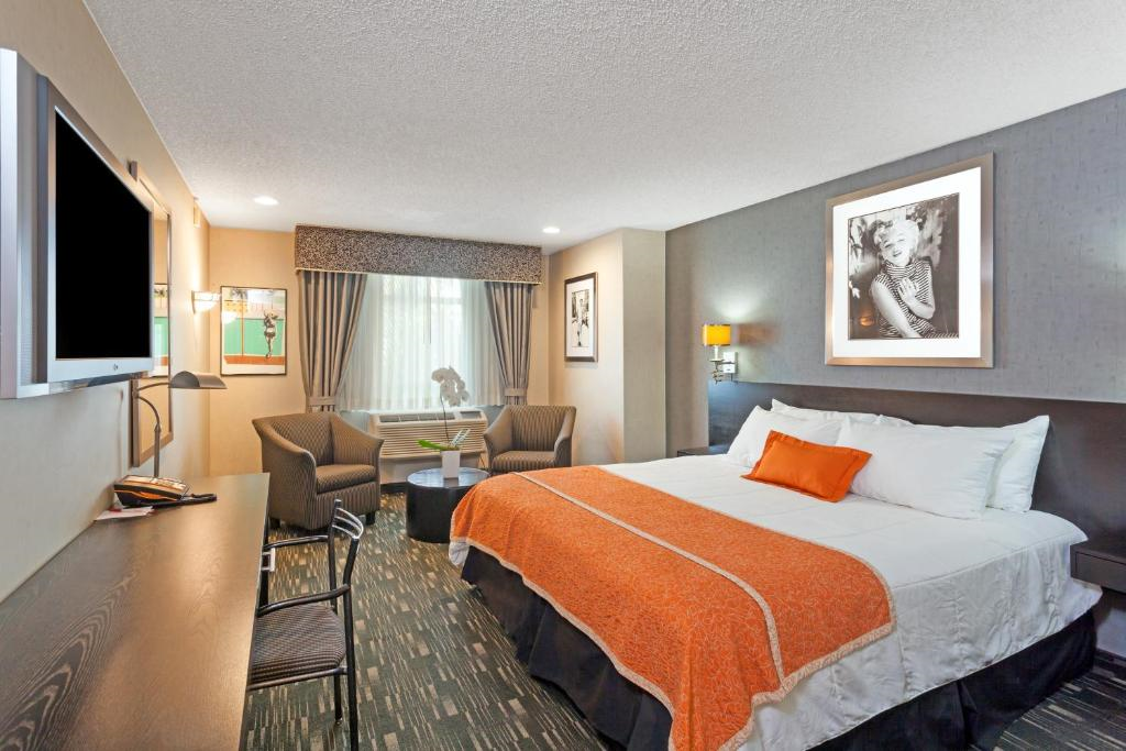 Enjoy a restful stay with a king bed, a cozy TV setup, and plush chairs for ultimate relaxation.