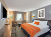 Enjoy a restful stay with a king bed, a cozy TV setup, and plush chairs for ultimate relaxation.