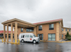 The exterior covered entrance to the Red Lion Hotel with a white van parked in front on an overcast day in Portland.