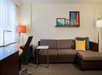 Studio suite living area with sofa bed and work desk.