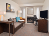 A relaxing living area with a comfortable sofa, fireplace, work desk and a flat-screen TV.