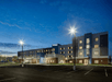 View for the front exterior of the Residence Inn by Marriott Columbus Airport  with an empty parking lot at dusk.
