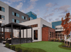 Ground view of the gray, blue, and white exterior of the Residence Inn by Marriott Columbus Airport on a cloudy day.