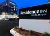 Residence Inn by Marriott building and sign illuminated at night, with cars parked in front.
