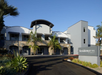Exterior view of a modern Residence Inn by Marriott hotel with palm trees and a clear blue sky.