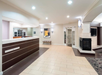 A modern hotel lobby with a tiled floor, a reception desk, a fireplace, artwork on the wall, and a cushioned bench.