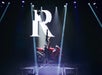 On top of a red motorcyle, Reza displays the rock symbol with his hand