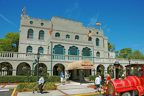 View of the front exterior of the The Castle Warden with people walking in front of it on a sunny day.