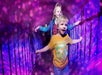 Two children walk across a narrow bridge with railings, surrounded by a vibrant pink and purple light display.