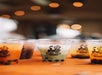Four cups of bubble tea with different flavors are placed on a wooden surface, each displaying the “Boba Tea” logo.