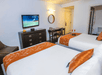 Guest room with 2 queen beds and flat-screen TV at Riviera Suites, FL.
