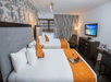 Guest room with 2 Queen beds, flat-screen TV and work desk.