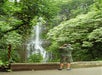 A man taking a photo of this waterfall can be seen on the Road to Hana tour in Maui Hawaii, USA.