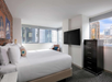 One king bed, a flat-screen TV, and a seating area inside a guest room.