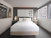 One king bed with plush bedding inside a guest room.