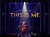 A performer in a red and white bodysuit stands center stage under a spotlight, with "THIS IS ME" illuminated in large letters behind them and dancers in the background.