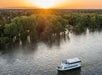 Aerial view of the Sacramento River: Alive After Five Cruise with the bright orange sun setting in the distance.