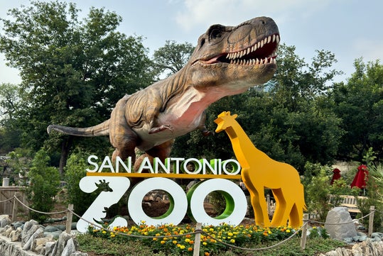 San Antonio Zoo's logo with huge Dinosaur statue in the entrance.