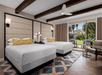 Two queen beds inside a guest room with a view.